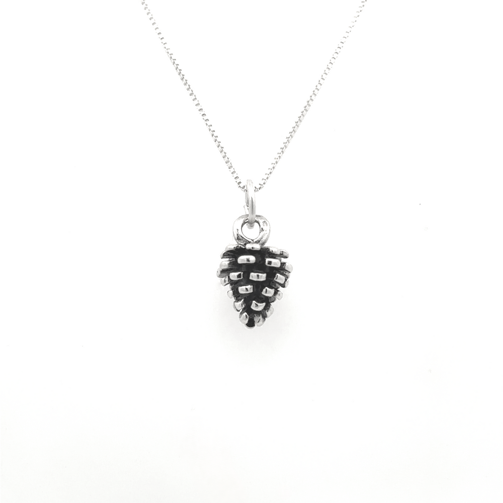 
                  
                    The Pinecone Pendant, a sterling silver necklace adorned with a delicate pinecone charm, is ideal for nature enthusiasts and is showcased beautifully against a white background.
                  
                