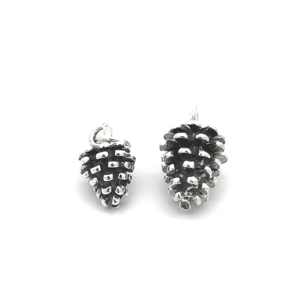 
                  
                    Two Pinecone Pendants, crafted from sterling silver, glisten on a white background—ideal for nature lovers.
                  
                