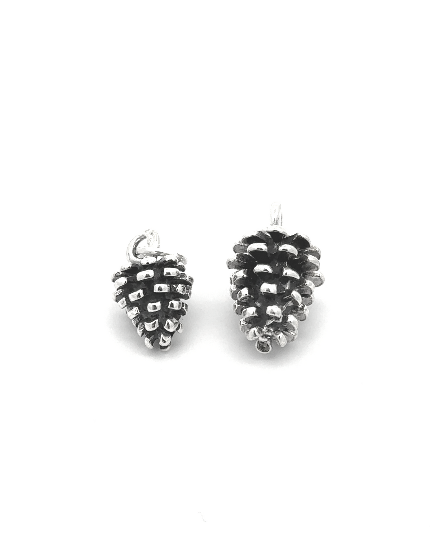 
                  
                    Two Pinecone Pendants, crafted from sterling silver, glisten on a white background—ideal for nature lovers.
                  
                