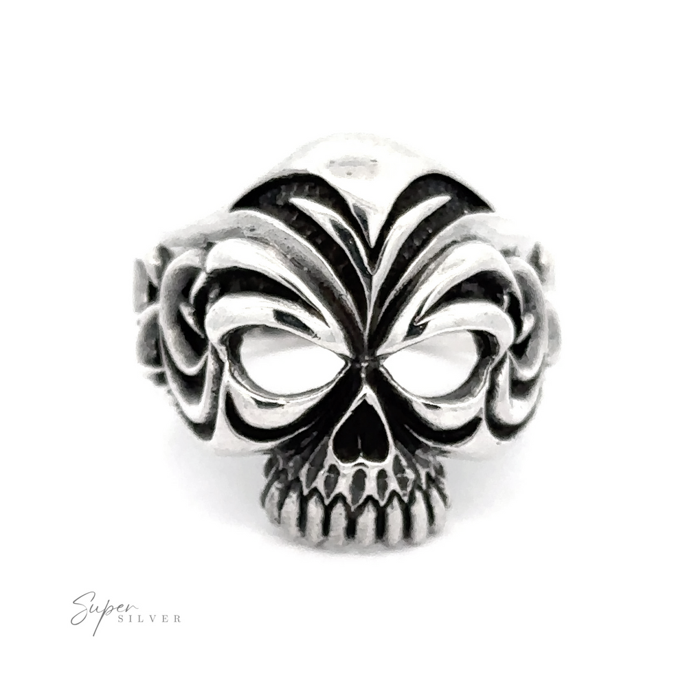 This Large Carved Skull Ring features a detailed skull design with intricate patterns around the eyes and forehead. The darkened finish highlights the bold style of the piece. The background is plain white, emphasizing the striking details of this Large Carved Skull Ring.