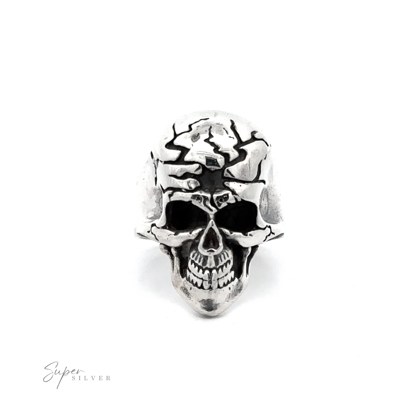 A silver ring shaped like a detailed skull with cracks and hollow eye sockets exudes edgy sophistication. "Super Silver" is written in small text at the bottom left corner. This Cracked Skull Statement Ring melds rebellious elegance with intricate craftsmanship, making it a standout accessory.