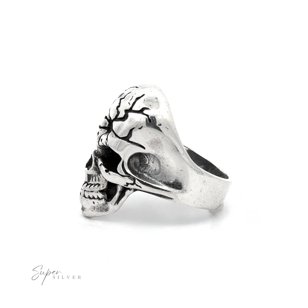 
                  
                    A silver Cracked Skull Statement Ring designed with a detailed skull motif, showing intricate engravings on the cranium. Exuding edgy sophistication and rebellious elegance, the brand name "Super Silver" is visible in the bottom left corner.
                  
                