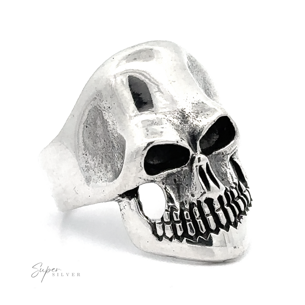 A Silver Skull Statement Ring, crafted in .925 sterling silver, featuring a detailed skull design with hollow eye sockets and visible teeth exudes edgy elegance. The brand name 