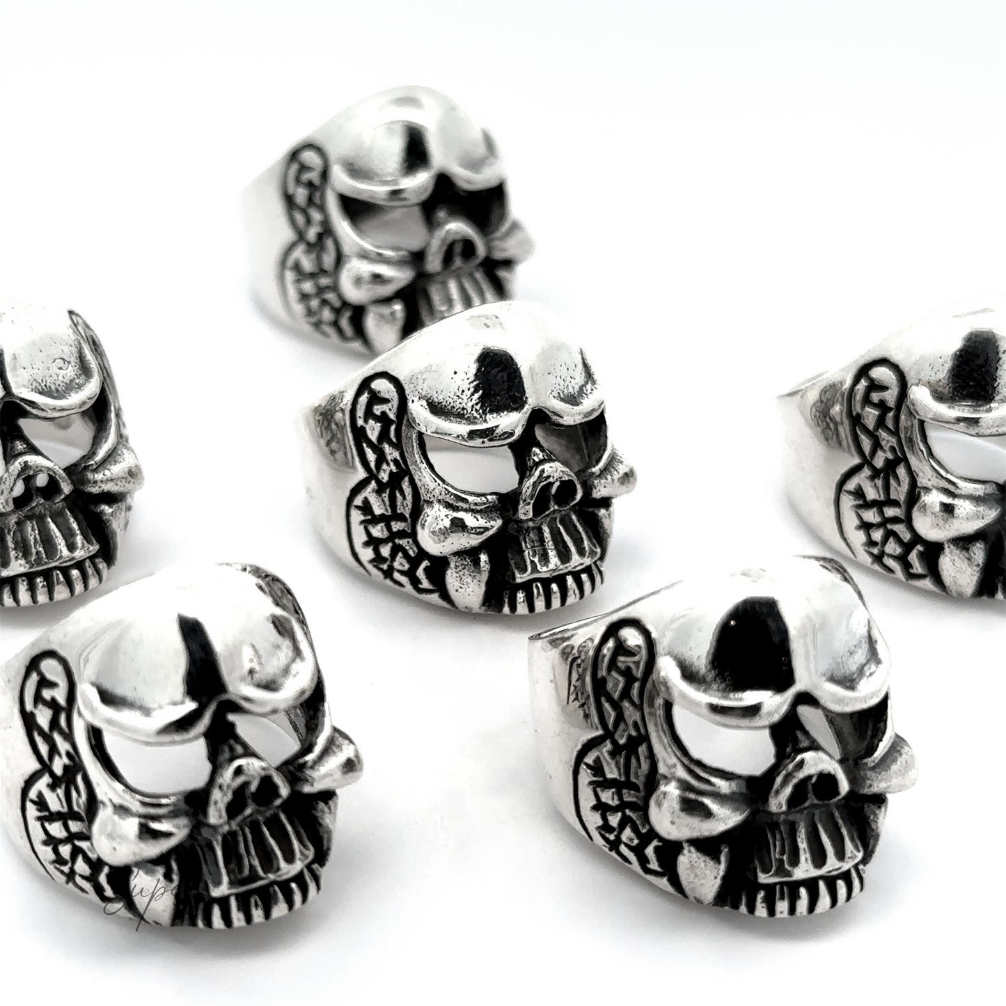 
                  
                    Six Skull Statement Rings with snake details, arranged on a white background, showcase an edgy style. Made from .925 Sterling Silver, these intricate pieces are perfect for adding a rebellious touch to any outfit.
                  
                