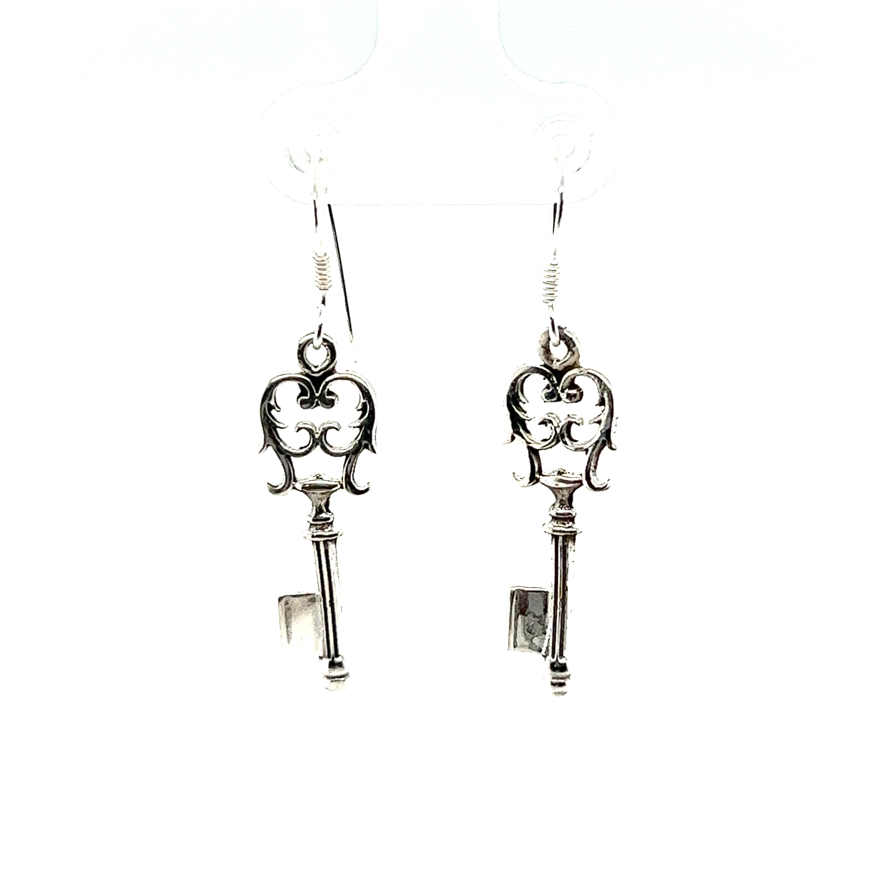 A pair of unique Super Silver Skeleton Key Earrings on a white background.
