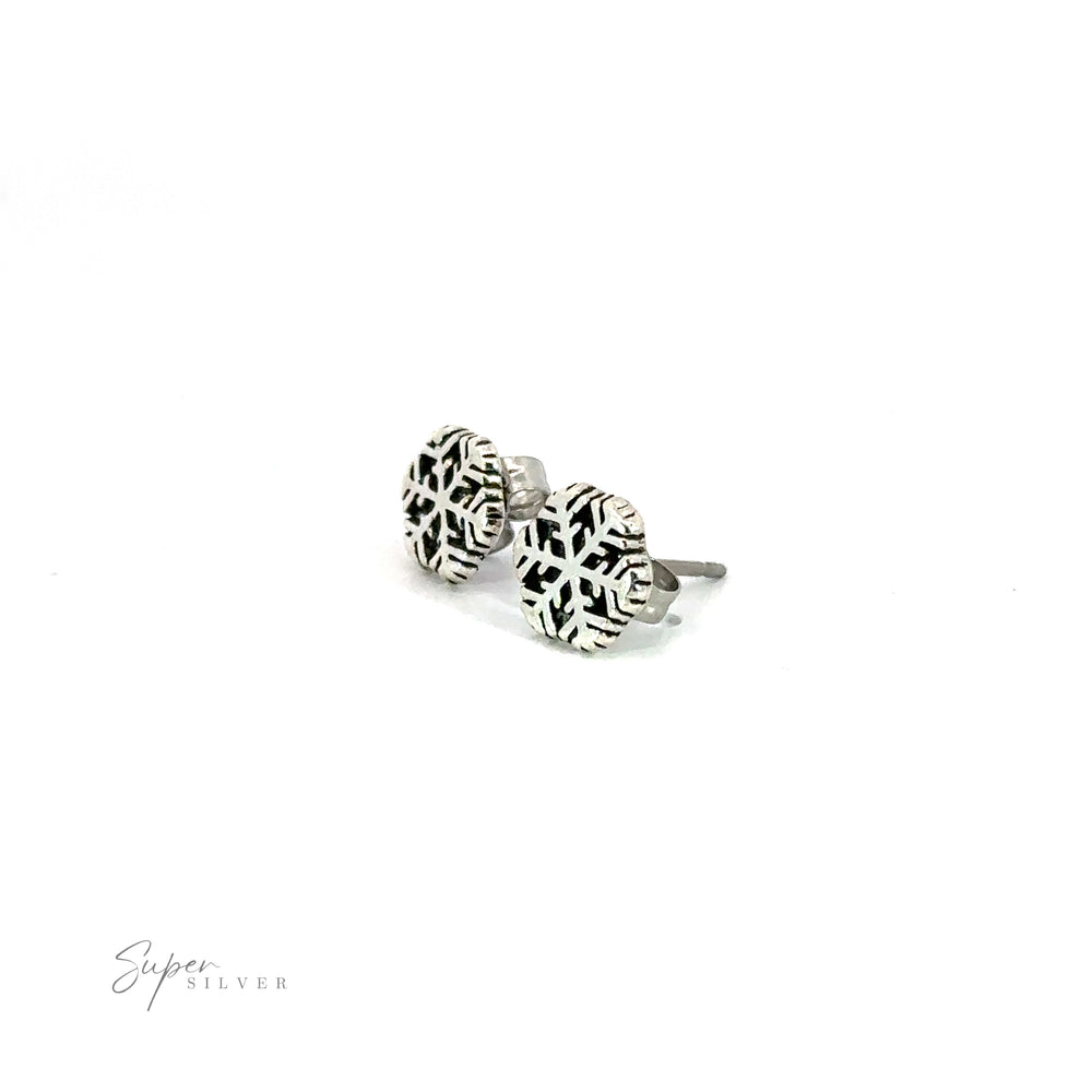A pair of Snowflake Studs featuring snowflake motifs on a white background.