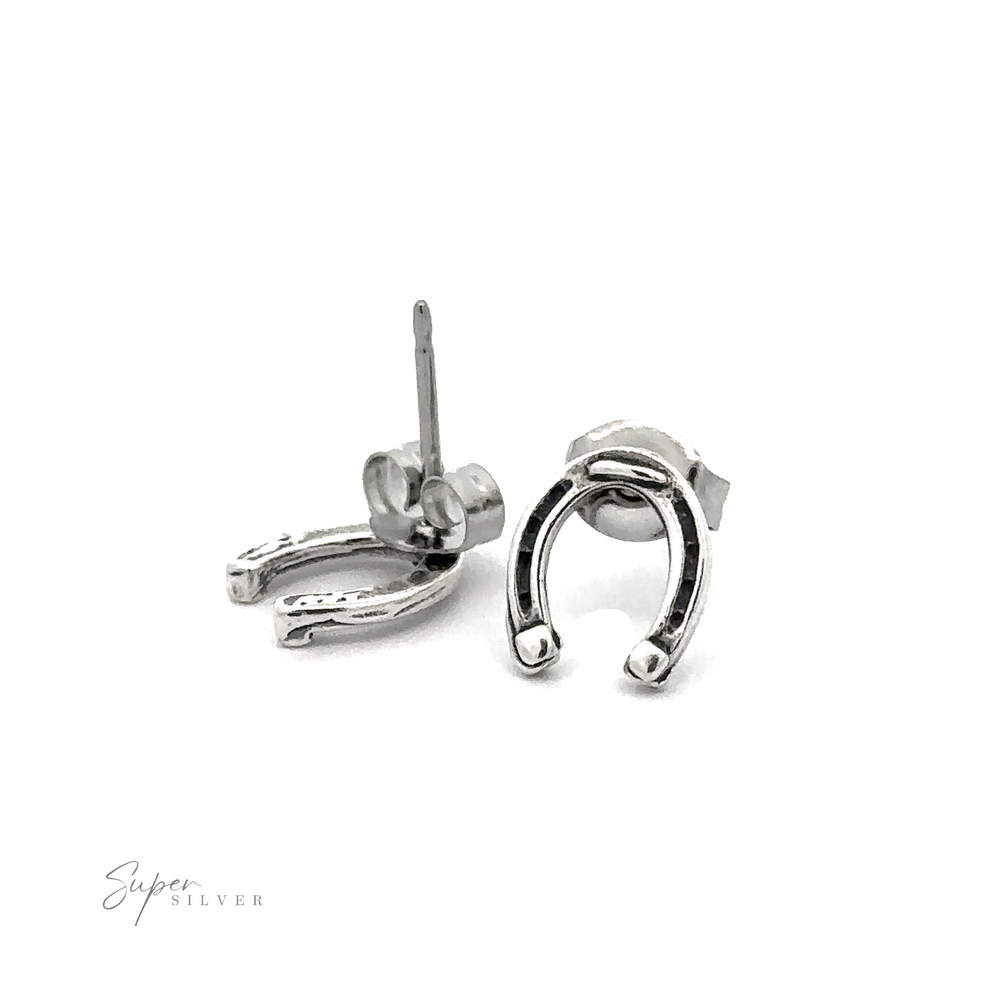 A pair of Horseshoe Studs, symbolizing luck, crafted in .925 Sterling Silver and placed on a white background.