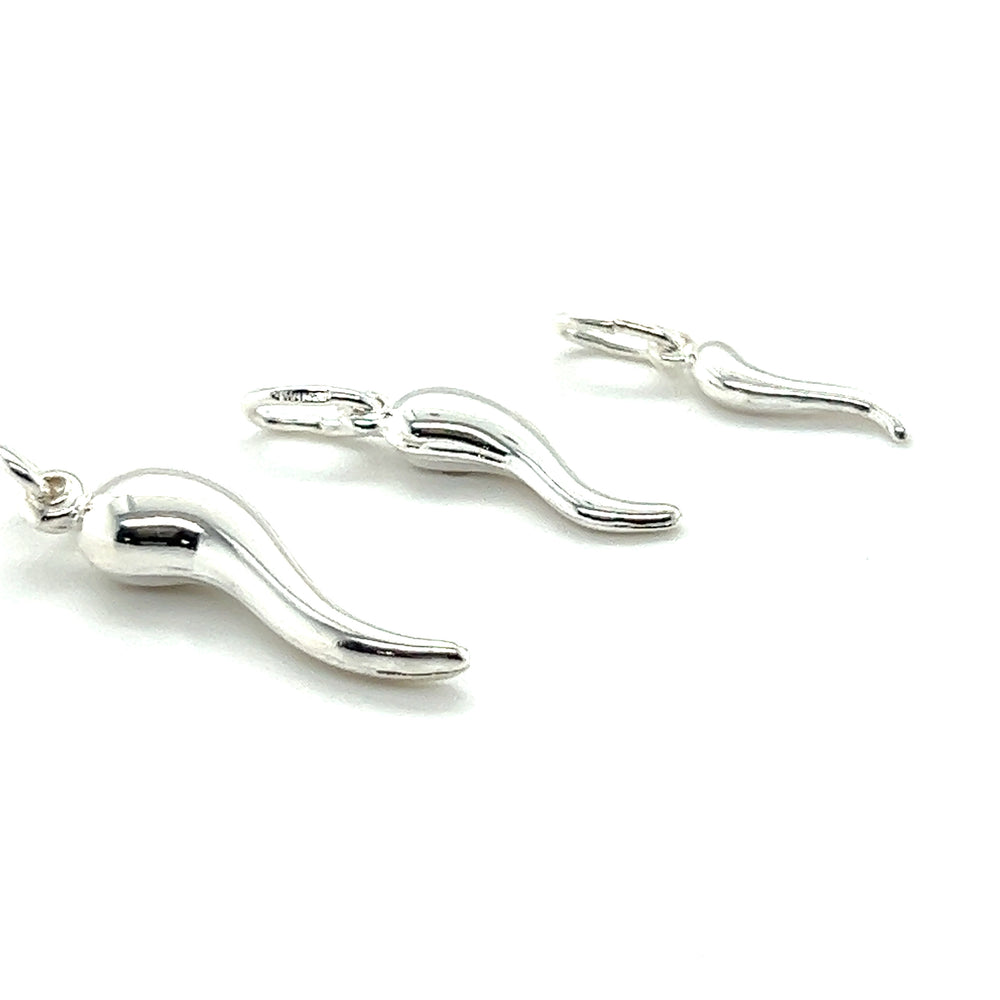 Three Super Silver Italian Horn Charms on a white surface.