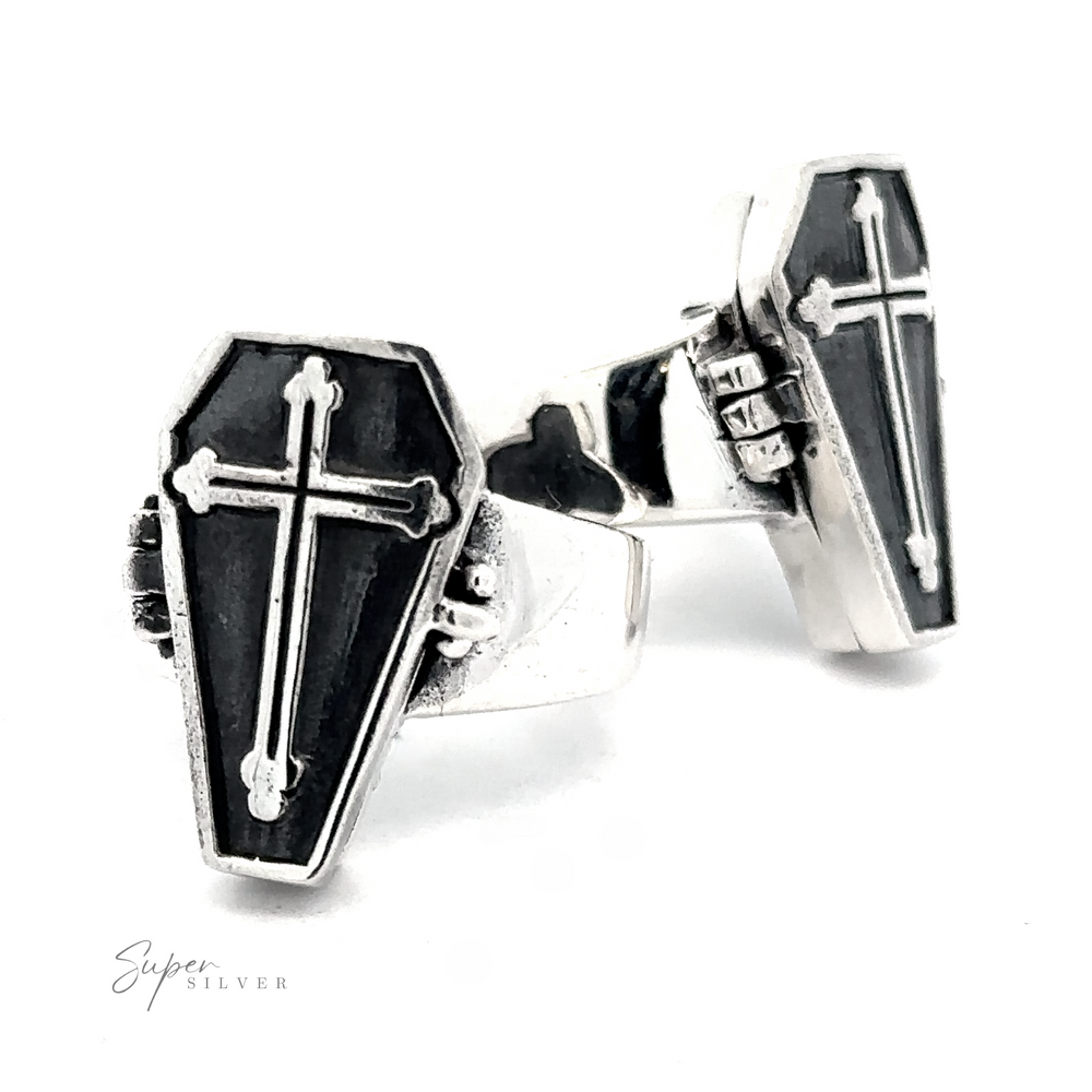 The Poison Coffin Ring with Cross, crafted from .925 Sterling Silver and featuring a coffin shape adorned with a cross design on the face, exudes gothic elegance.