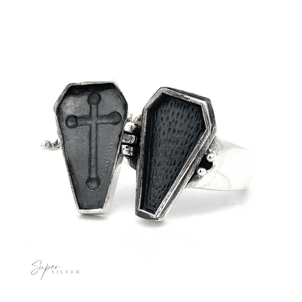 The Poison Coffin Ring with Cross by Super Silver is a silver ring designed with two hinged coffin lids, one showcasing a cross and the other an empty space, embodying gothic elegance in .925 sterling silver.