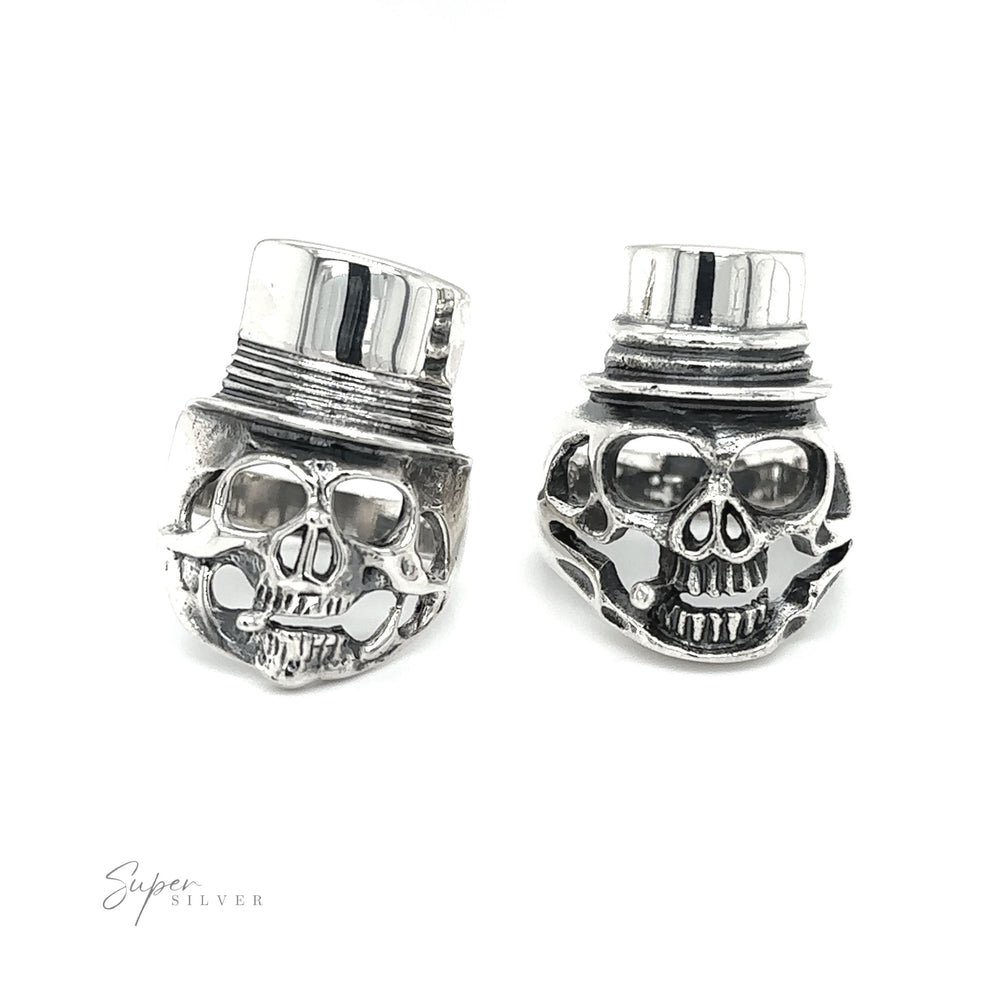 A pair of silver skull cufflinks on a white background, combining edgy fashion with trendy accessories. The Skull Ring with Top Hat combines edgy fashion with trendy accessories.