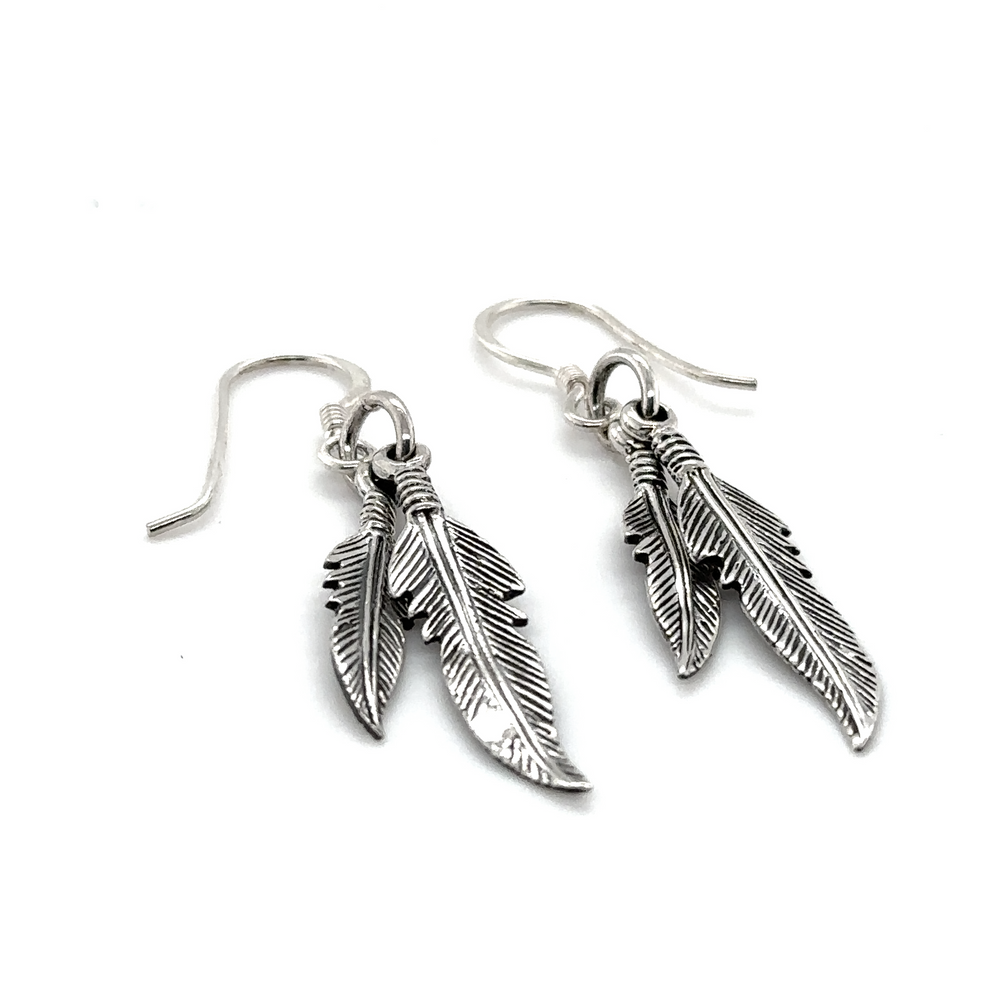 
                  
                    A pair of Super Silver Double Feather Earrings with french hook on a white background.
                  
                