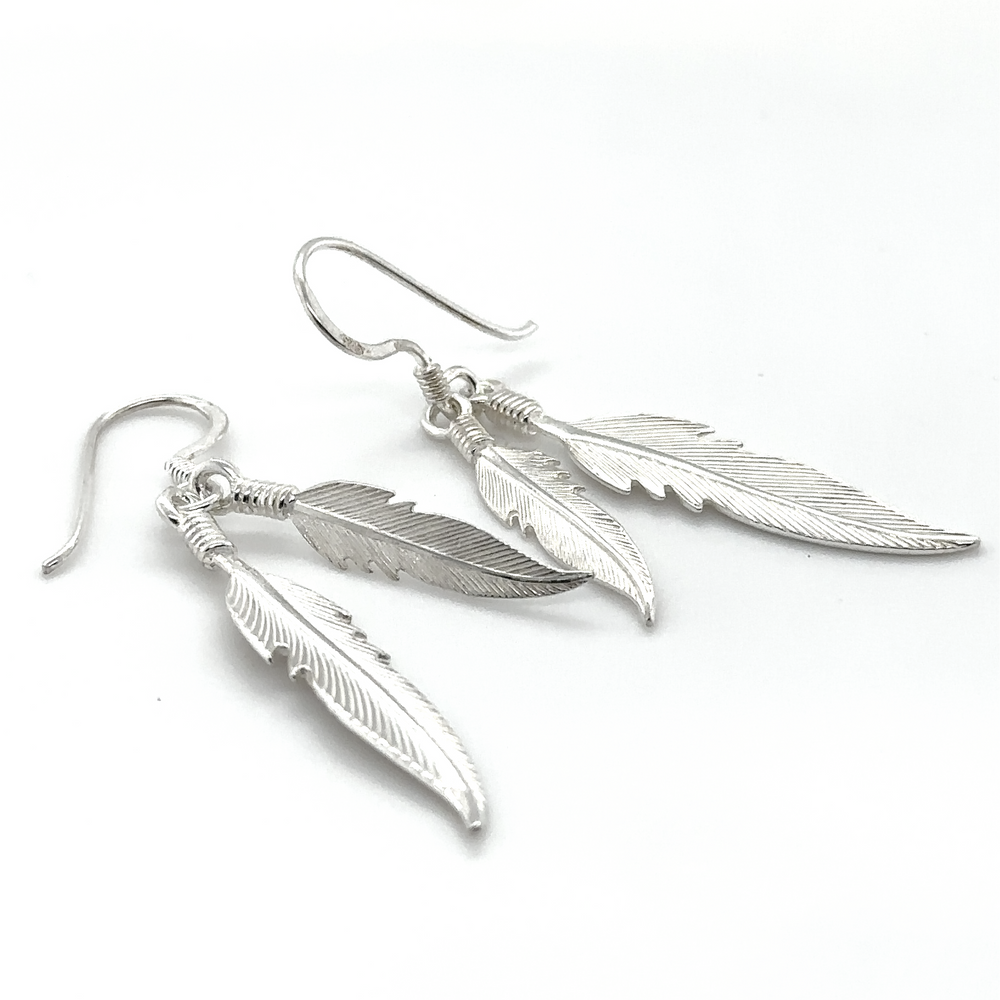 
                  
                    A pair of Super Silver Double Feather Earrings on a white background.
                  
                