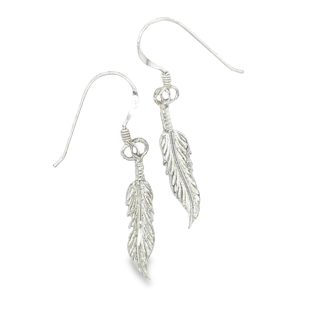 A pair of Super Silver Tiny Feather earrings with a minimalist boho style.
