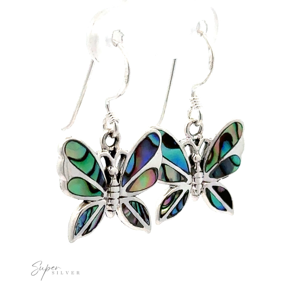 
                  
                    Sentence with Product Name: A pair of Brewster Abalone Butterfly Earrings, .925 Sterling Silver with multicolored inlays, hanging from silver hooks, isolated on a white background.
                  
                