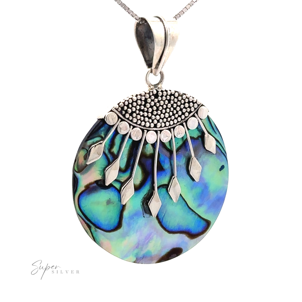 A Circle Abalone Pendant featuring a vibrant abalone shell with intricate Bali detail on top and a silver chain. The abalone shell showcases a mix of green, blue, and black hues.