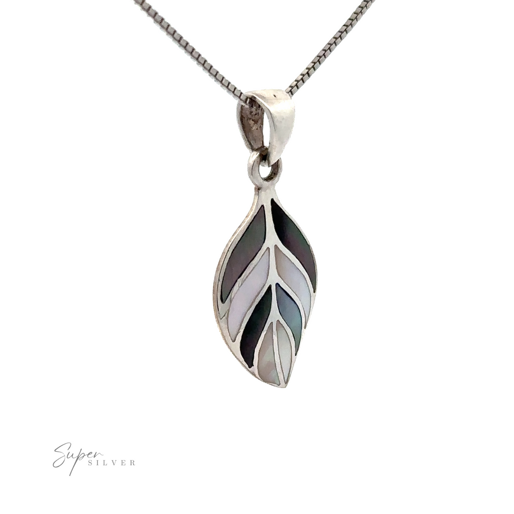 
                  
                    Stone Inlaid Leaf Pendant: This silver necklace features a leaf-shaped pendant with inlaid mother-of-pearl accents, hanging gracefully on a fine chain against a white background.
                  
                