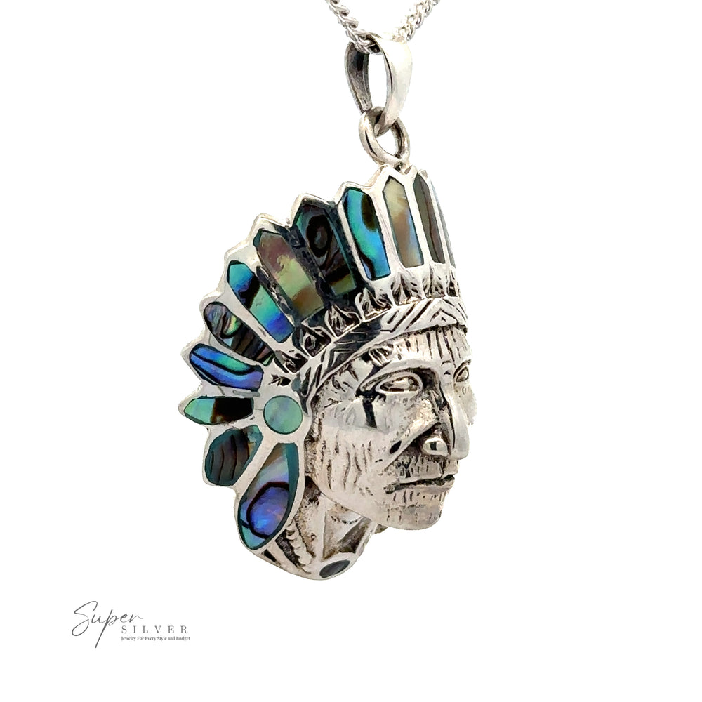 
                  
                    A stunning Chief Pendant With Inlaid Stones in the shape of a Native American chief's head, featuring intricate silver detailing and iridescent abalone turquoise inlays.
                  
                