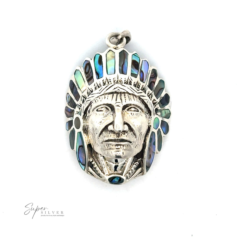 
                  
                    A Chief Pendant With Inlaid Stones crafted from sterling silver features a detailed face wearing a headdress adorned with abalone shell inlays. The text "Super Silver" is visible in the bottom left corner.
                  
                