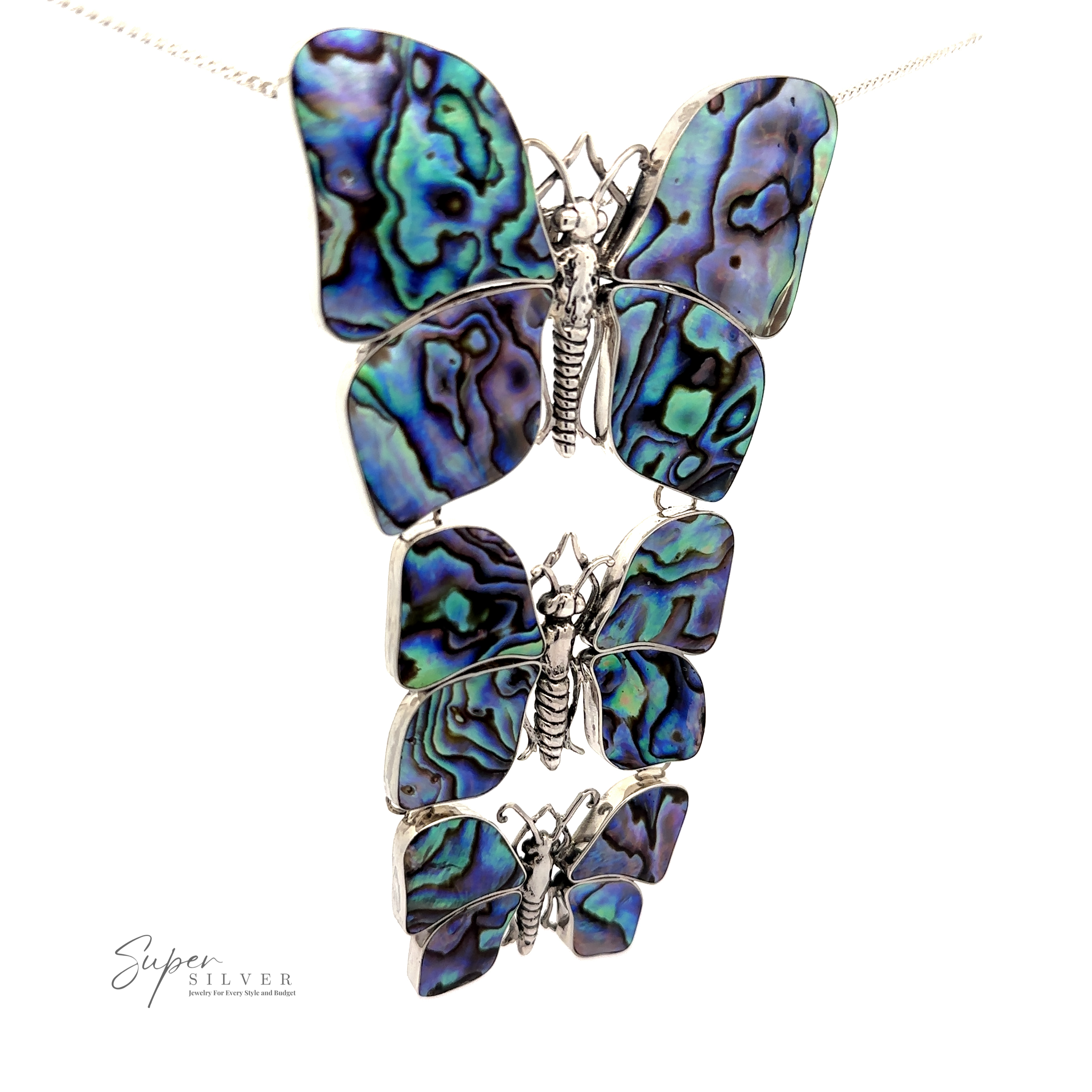 A Statement Pendant or Brooch with Three Butterflies made from abalone shell, displaying iridescent blue and green patterns on a white sterling silver background—perfect for the nature lover.