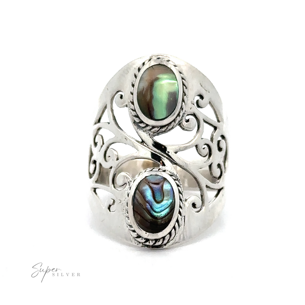 
                  
                    The Boho-Inspired Ring With Inlaid Stones features a silver filigree shield design adorned with two oval-shaped abalone shell stones, embedded in an intricate, swirling pattern with a bohemian touch. The ring showcases detailed metalwork and includes the "Super Silver" text on the bottom left.
                  
                