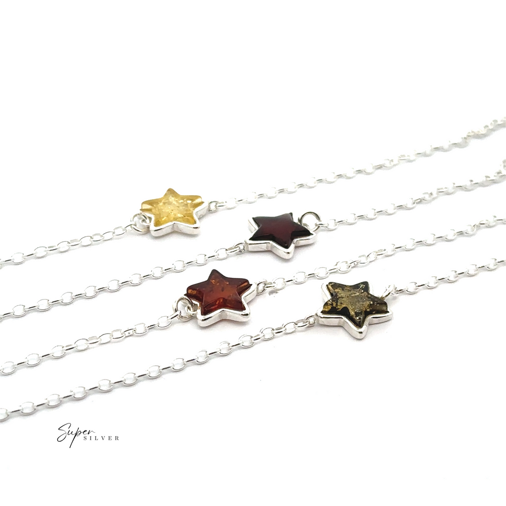 The Simple Amber Star Bracelet, featuring sterling silver chains with star-shaped pendants available in an array of colors—yellow, dark brown, light brown, and black—is artfully displayed diagonally on a white background, highlighting the elegance of minimalist design in each piece.