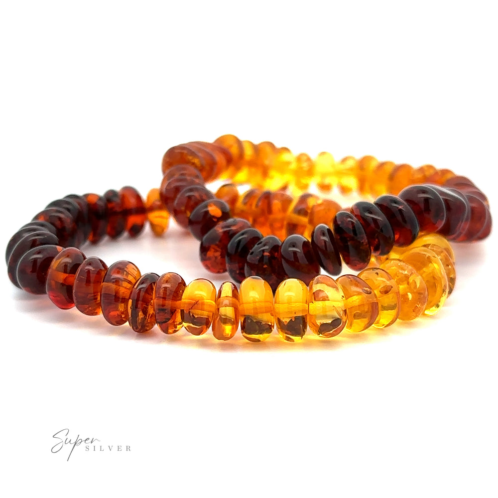 Two Outstanding Baltic Amber Rondelle Beaded Bracelets, one dark brown and the other light yellow, arranged in a loose circular pattern on a white background, exude a boho vintage style that's simply captivating.