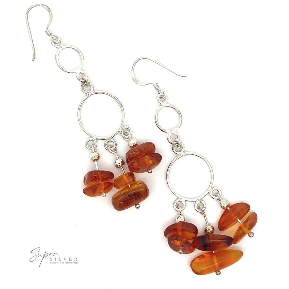 A pair of sterling silver Hoop Dangle Earrings with Amber featuring silver hoops with amber-colored stone beads hanging from them. The Baltic amber earrings are displayed against a white background, with the "Super Silver" logo in the bottom left corner.
