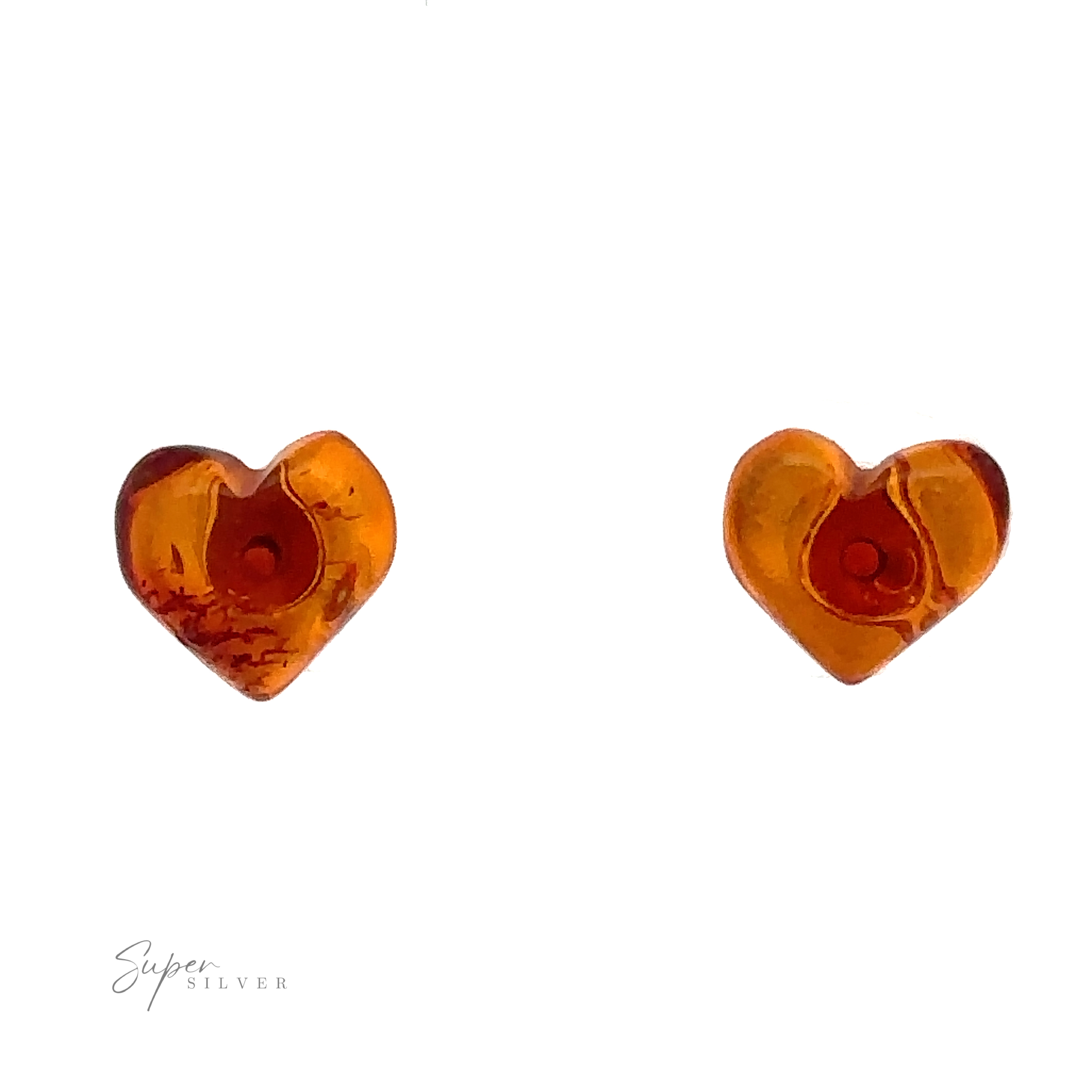 A pair of small heart-shaped amber earrings with dark inclusions, set against a white background. The bottom left corner has the words "Super Silver" written in script font. These Amber Heart Studs are perfect for anyone who appreciates Baltic Amber Jewelry’s timeless elegance.