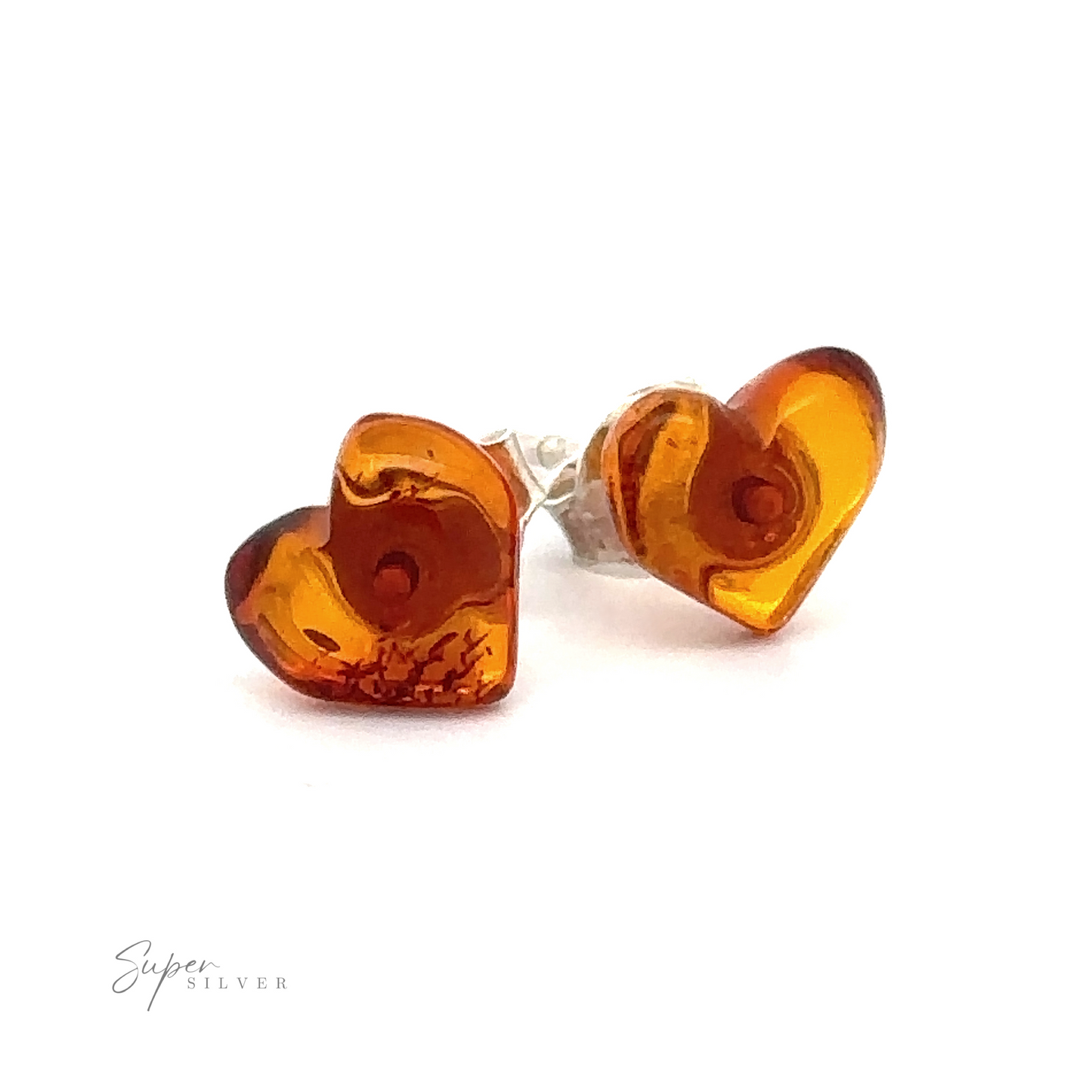 Two heart-shaped Amber Heart Studs with a polished, translucent finish are displayed on a white background. The earrings are positioned at an angle, showing their depth and texture. "Super Silver" is written in the bottom-left corner.