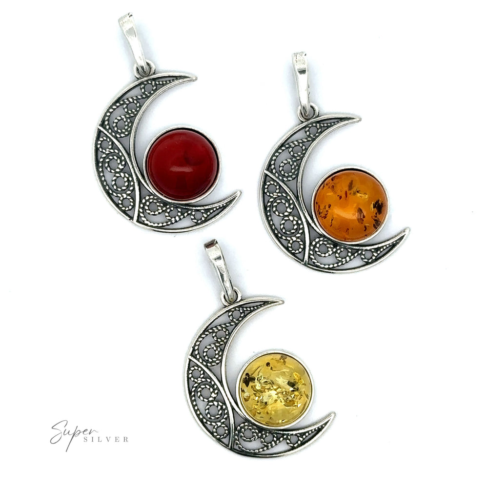 
                  
                    Three sterling silver crescent moon pendants with intricate designs, each featuring a central colored gemstone: red, orange, and yellow. One of them highlights a stunning Baltic Amber Moon Pendant.
                  
                