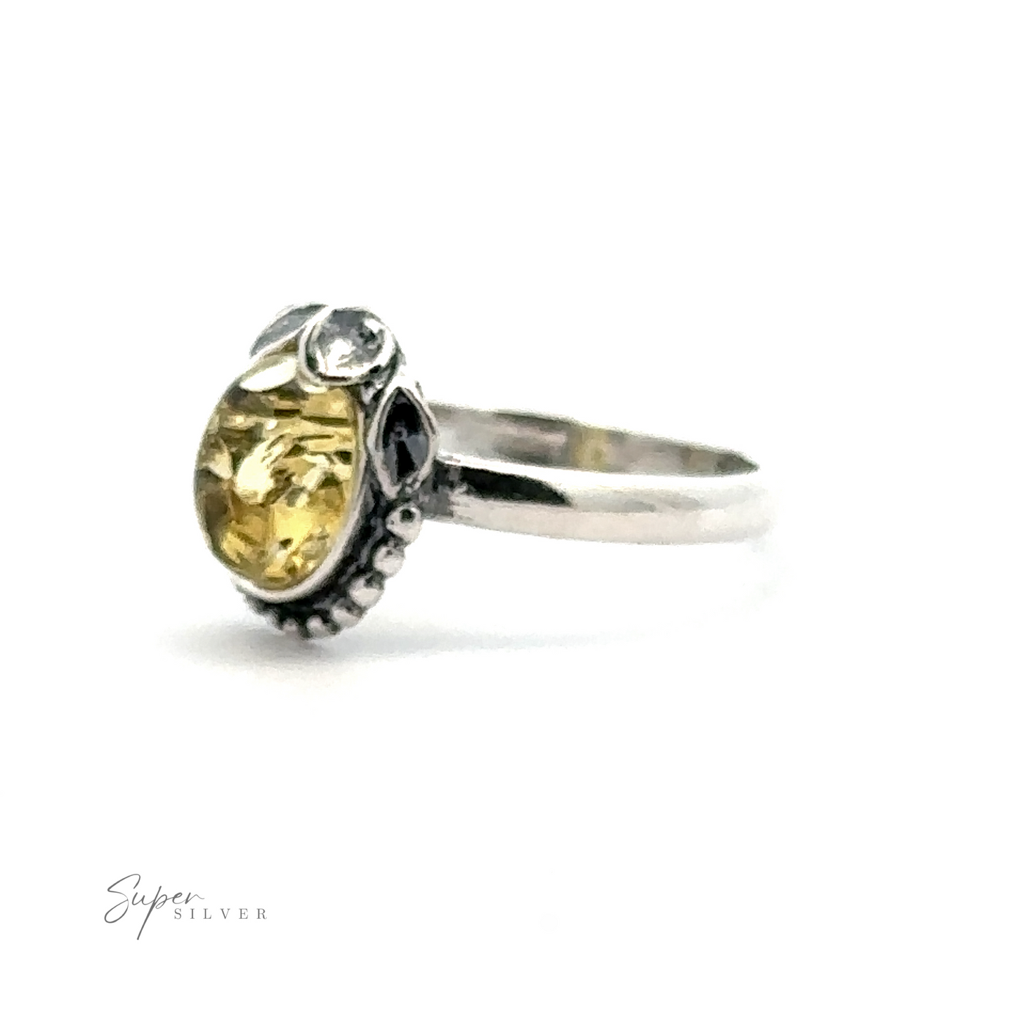 
                  
                    A sterling silver ring featuring a vintage elegance with an oval yellow gemstone in a detailed setting and small decorative elements. The "Amber Ring with Beaded Border and Peace Lily Details" graces the bottom left corner, reflecting nature-inspired jewelry.
                  
                