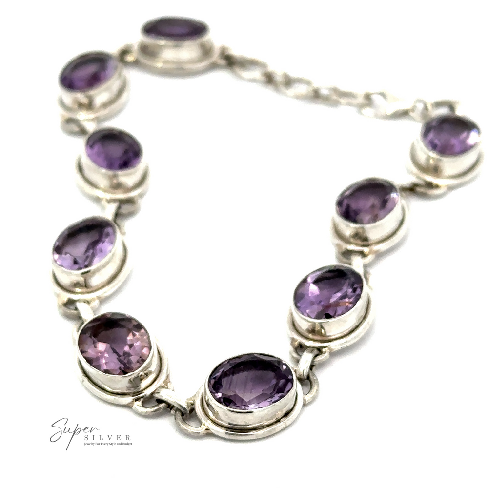 The Stunning Amethyst Bracelet is crafted from sterling silver and features a captivating lineup of eight oval amethyst gemstones, expertly linked in a singular chain. It is an ideal statement piece that infuses elegance into any ensemble.