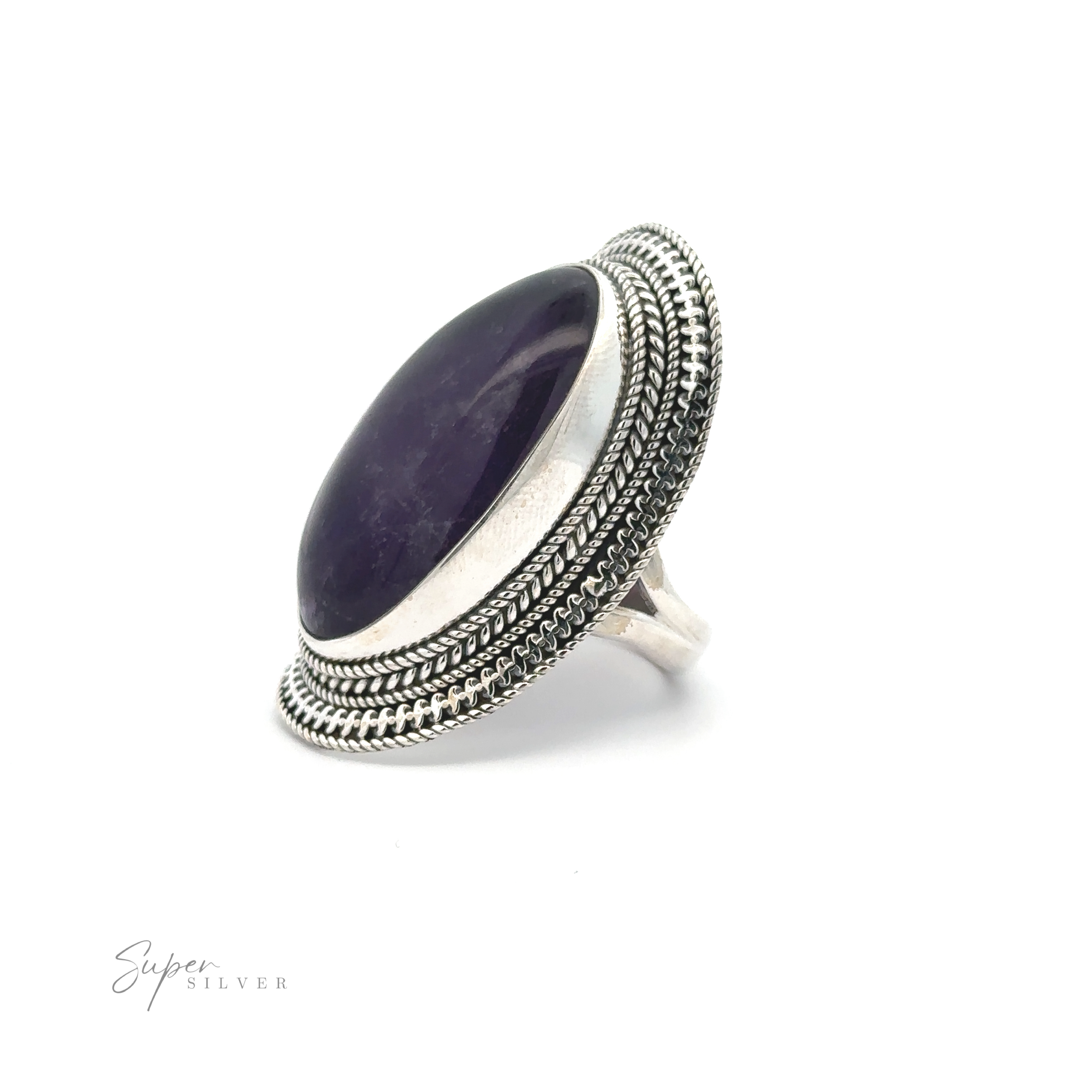 Large Oval Shield Gemstone Ring with a large oval purple gemstone set into an ornate bezel. The detailed metalwork around the stone adds a bohemian flair to this stunning piece. "Super Silver" is written in the bottom left corner.