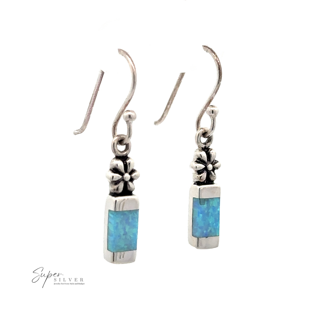 Blue Created Opal Earrings with Flower. Pair of .925 sterling silver dangle earrings featuring rectangular blue created opal stones and flower details.