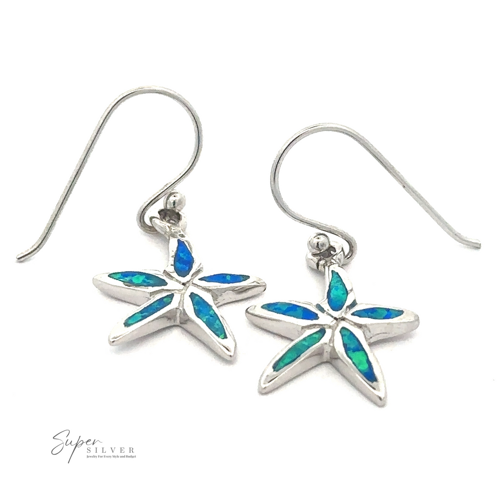 A pair of Lab-Created Opal Star Fish Earrings with dazzling blue and green inlays. The earrings have hook-style fastenings, and the brand 