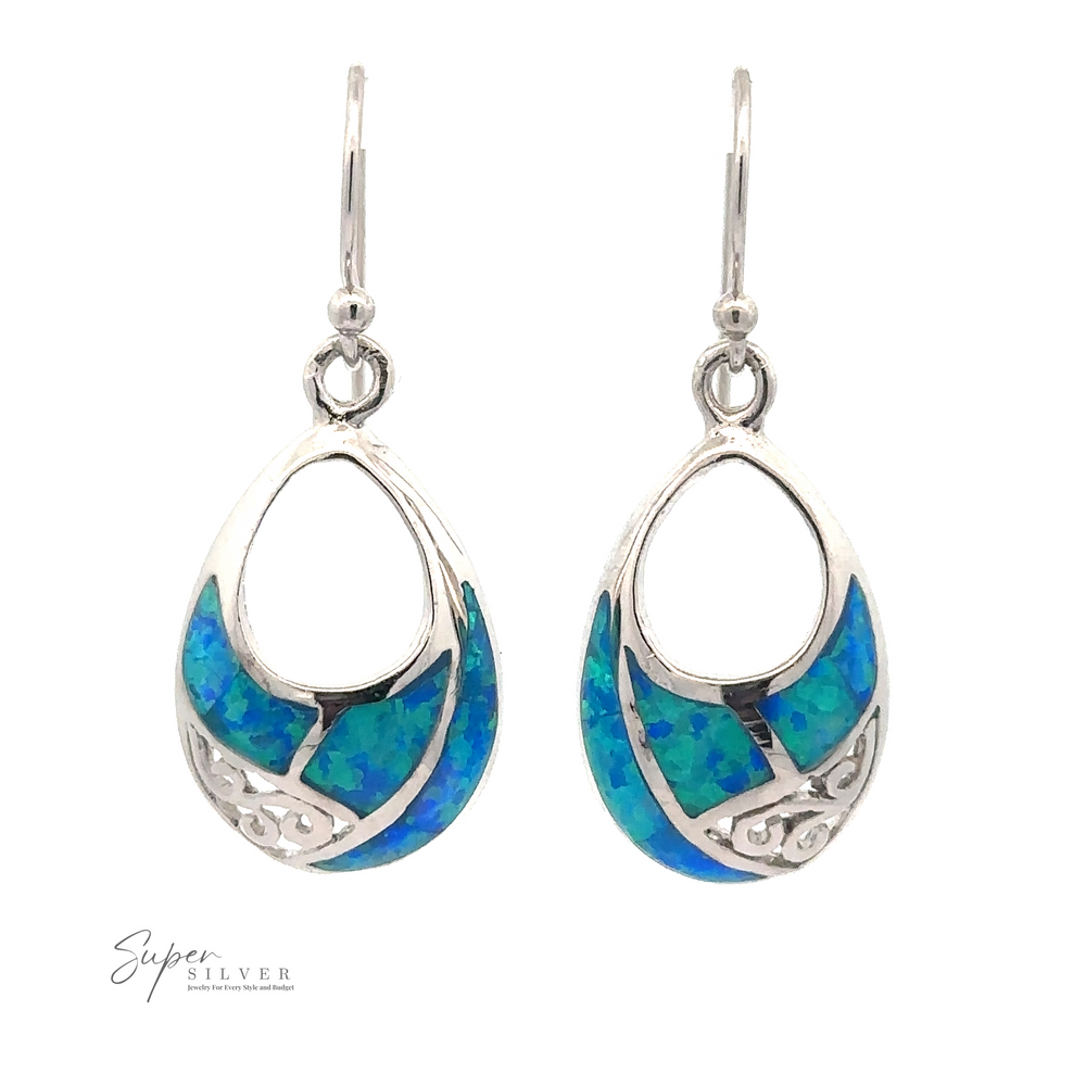 
                  
                    Blue Created Opal Teardrop Earrings with intricate design details and finished with a rhodium coating, displayed on a white background.
                  
                