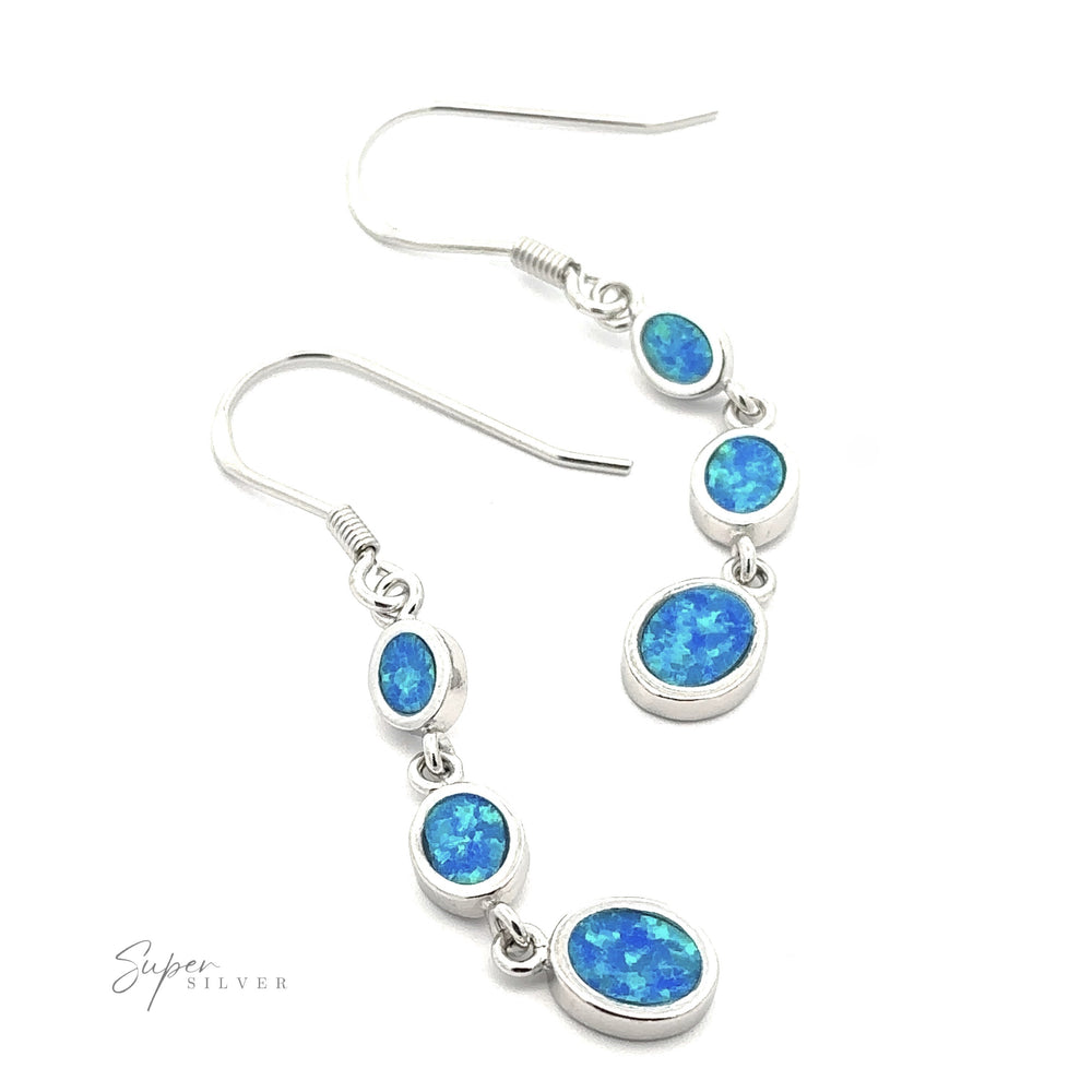 The Long Oval Blue Lab-Created Opal Earrings feature a geometric design with three blue lab-created opal stones of varying sizes set in each sterling silver earring.