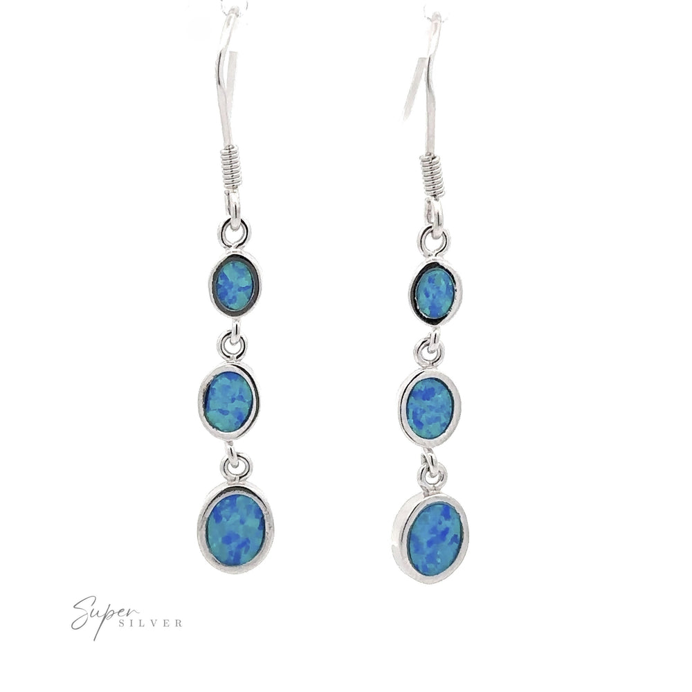 
                  
                    Long Oval Blue Lab-Created Opal Earrings showcasing a geometric design with three blue lab-created opal stones of varying sizes, arranged in descending order, on a white backdrop.
                  
                