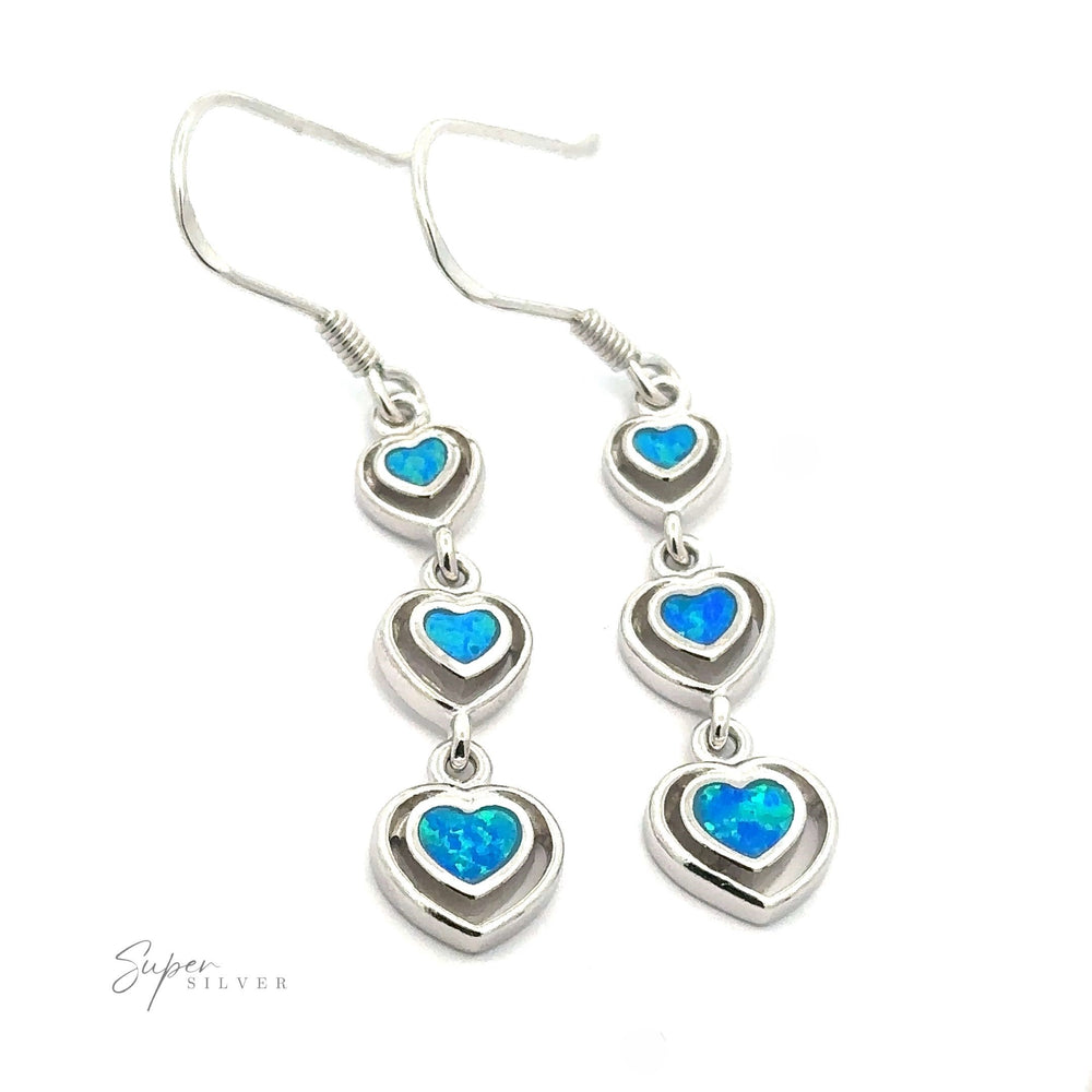 
                  
                    Product Description: "Dangling Lab-Created Opal Heart Earrings crafted from sterling silver, featuring three stacked heart-shaped charms, each showcasing a lab-created blue opal-like center.
                  
                