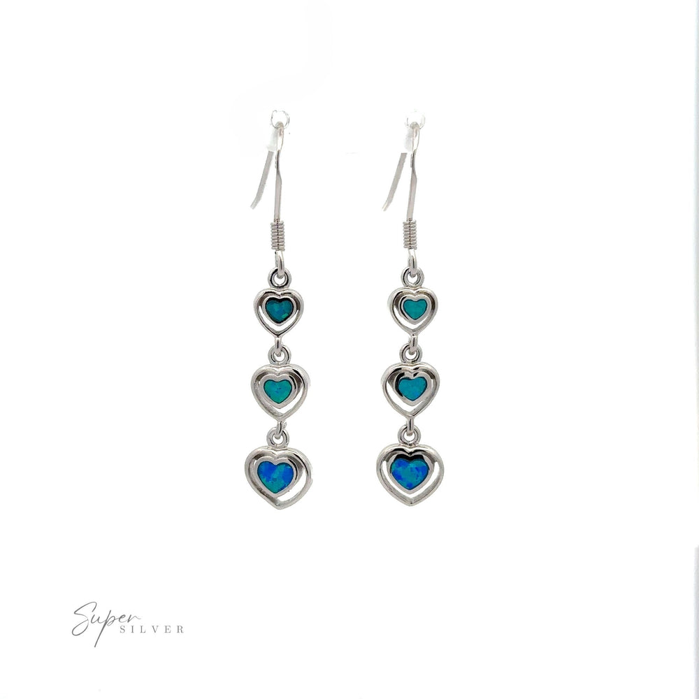 
                  
                    A pair of Dangling Lab-Created Opal Heart Earrings featuring three small turquoise and lab-created blue heart-shaped opal stones in each earring, displayed on a white background.
                  
                