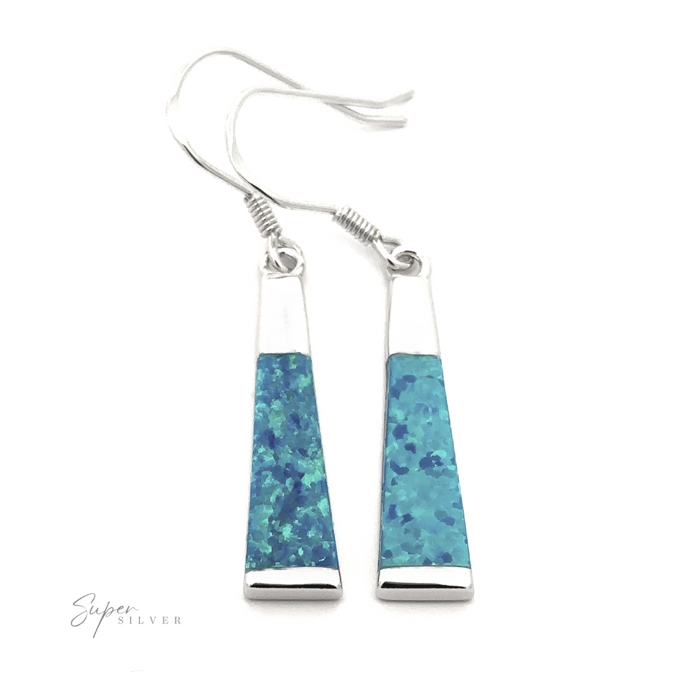 
                  
                    A pair of Elegant Long Opal Earrings featuring elongated, trapezoidal pendants with a blue-speckled pattern adds modern flair for the contemporary artsy woman. The brand name "Super Silver" is visible in the bottom left corner.
                  
                