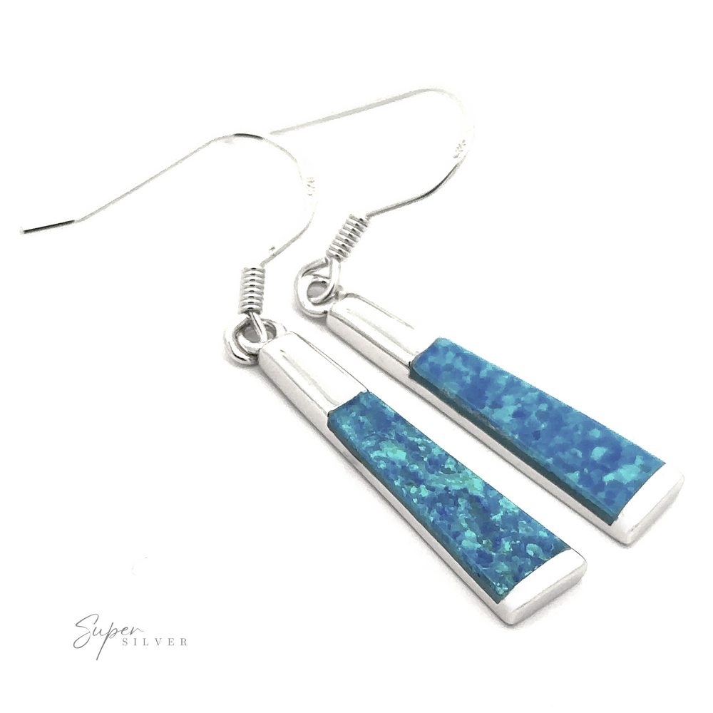 
                  
                    The Elegant Long Opal Earrings feature silver hooks and blue rectangular pendants with a textured, mosaic design that showcases varying shades of blue and green. This modern accessory is ideal for the contemporary artsy woman.
                  
                