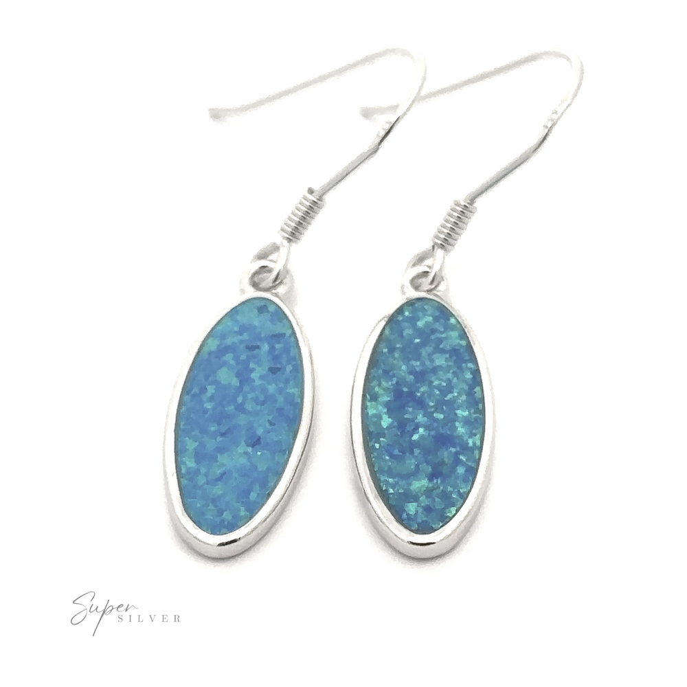 
                  
                    Two oval-shaped silver earrings featuring blue lab-created opal gemstones, each with a fishhook wire. The earrings are set against a white background and labeled "Simple Oval Lab-Created Opal Earrings" in the corner.
                  
                