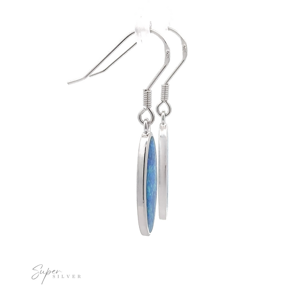 
                  
                    Close-up of a pair of Simple Oval Lab-Created Opal Earrings with silver dangles and oval blue opal gemstones, hanging from hooks. The logo "Super Silver" is visible in the bottom left corner.
                  
                