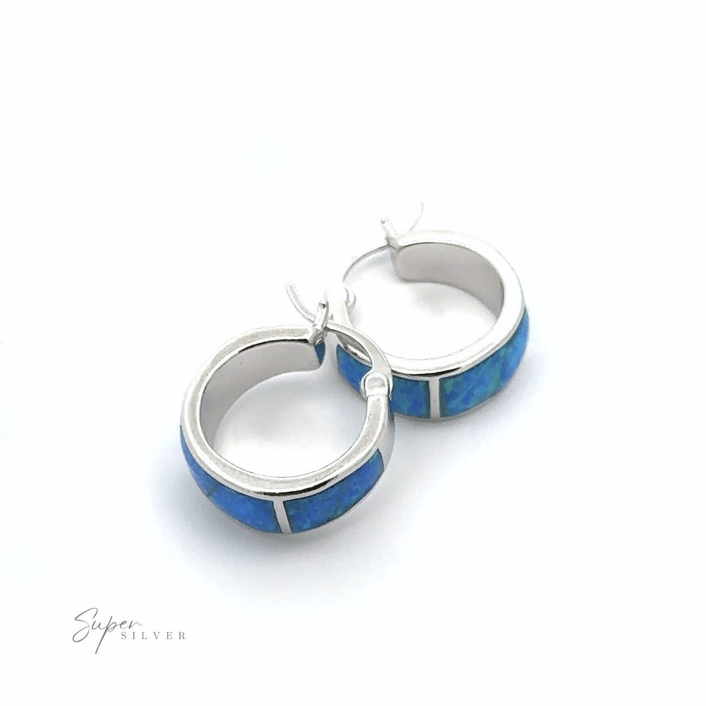 
                  
                    A pair of Blue Lab-Created Opal Huggie Hoop Earrings with a rhodium finish.
                  
                