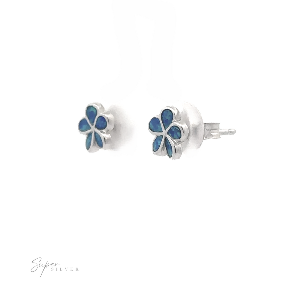 
                  
                    A pair of Small Plumeria Lab-Created Opal Stud Earrings, crafted in sterling silver with a flower design. The earrings feature blue lab-created opal inlays on a white background, with 'Super Silver' text in the lower left corner.
                  
                