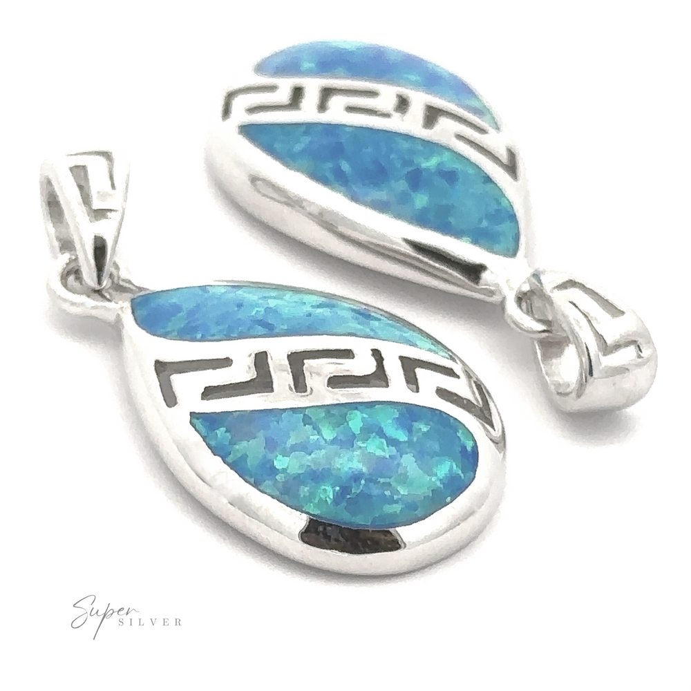 Two Teardrop Lab-Created Opal Pendants in silver and blue, showcasing a geometric Greek key design, displayed against a white background. The branding 