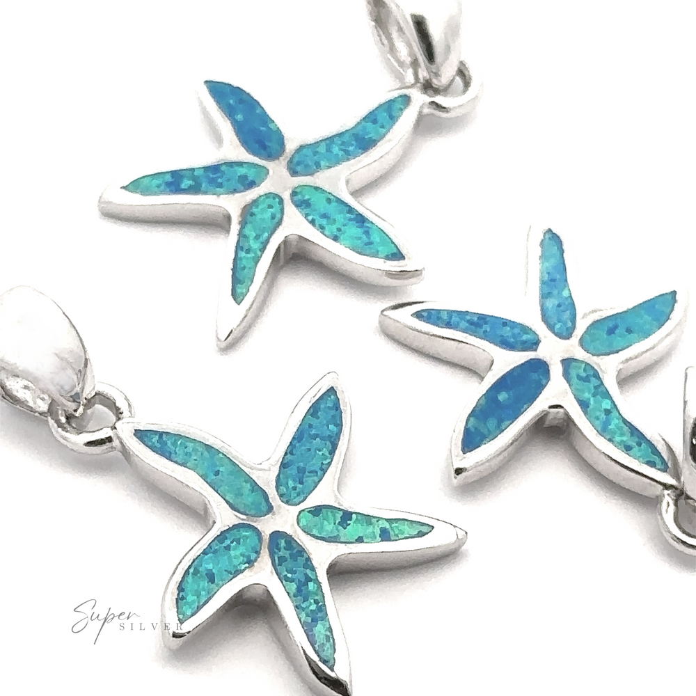 
                  
                    Three Lab-Created Opal Sea Star Pendants with blue and green iridescent inlays and silver borders are displayed against a white background. The word "Super Silver" is visible in the lower left corner, highlighting the elegance of these designs.
                  
                