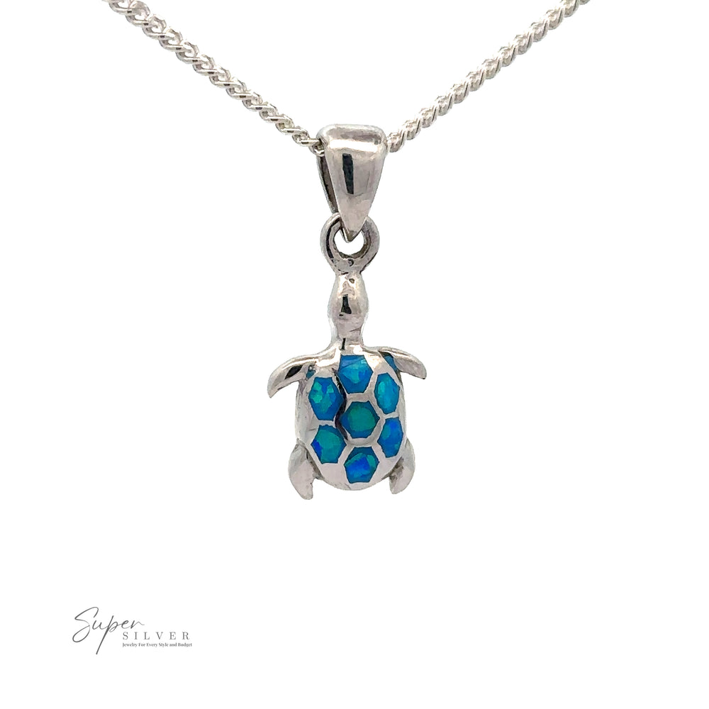 
                  
                    A Dainty Blue Opal Sea Turtle Pendant. The turtle shell features blue and green hexagonal patterns, evocative of marine life with striking blue opal stones. The chain is a twisted rope design, and the logo "Super Silver" is visible.
                  
                